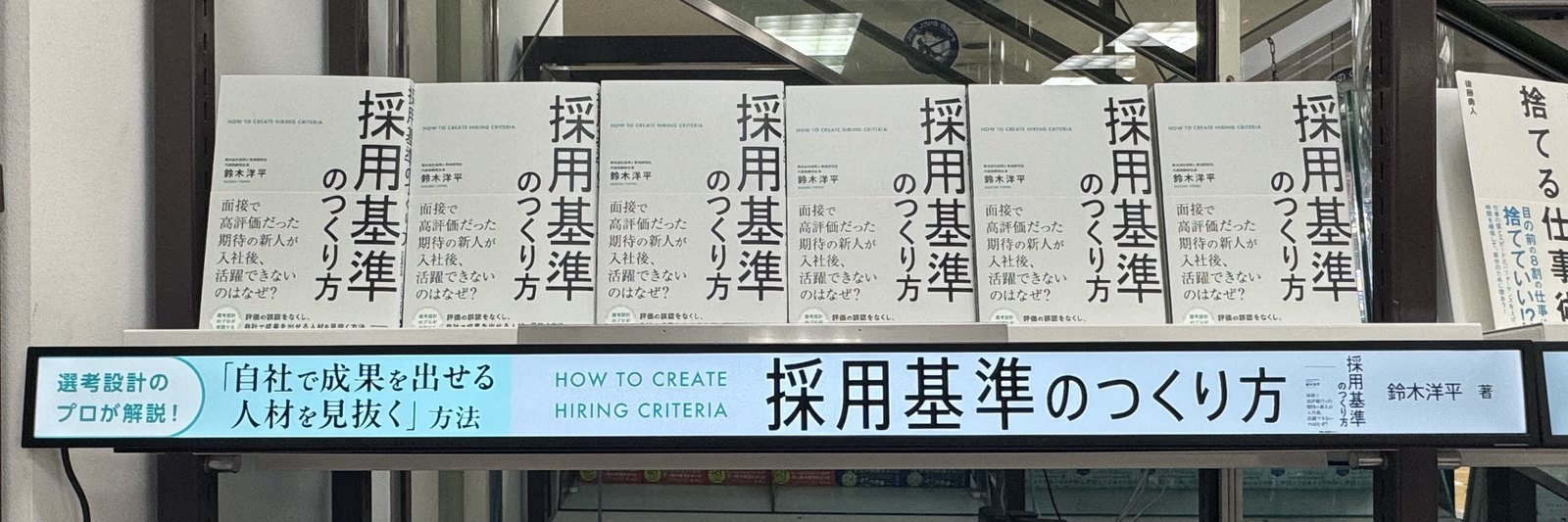 池袋ジュンク堂書店1階のサイネージ付き棚に並ぶ『採用基準のつくり方』